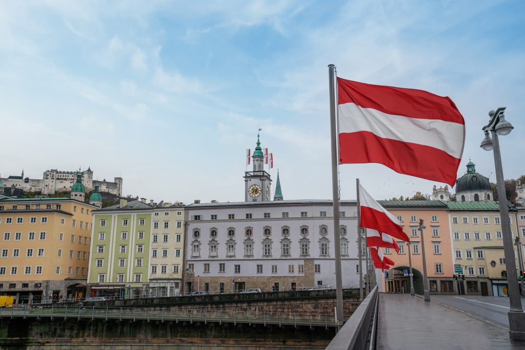 Blick auf die Stadt Salzburg mit mehreren österreichischen Flaggen im Bild