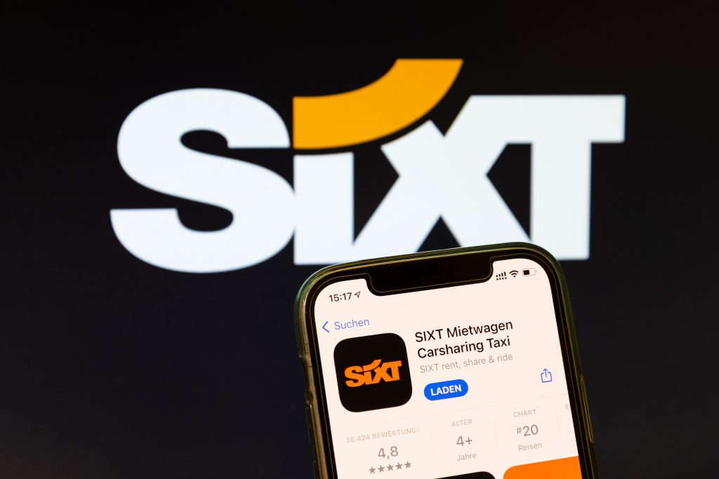 SIXT Logo mit geöffneter Iphone-App von SIXT