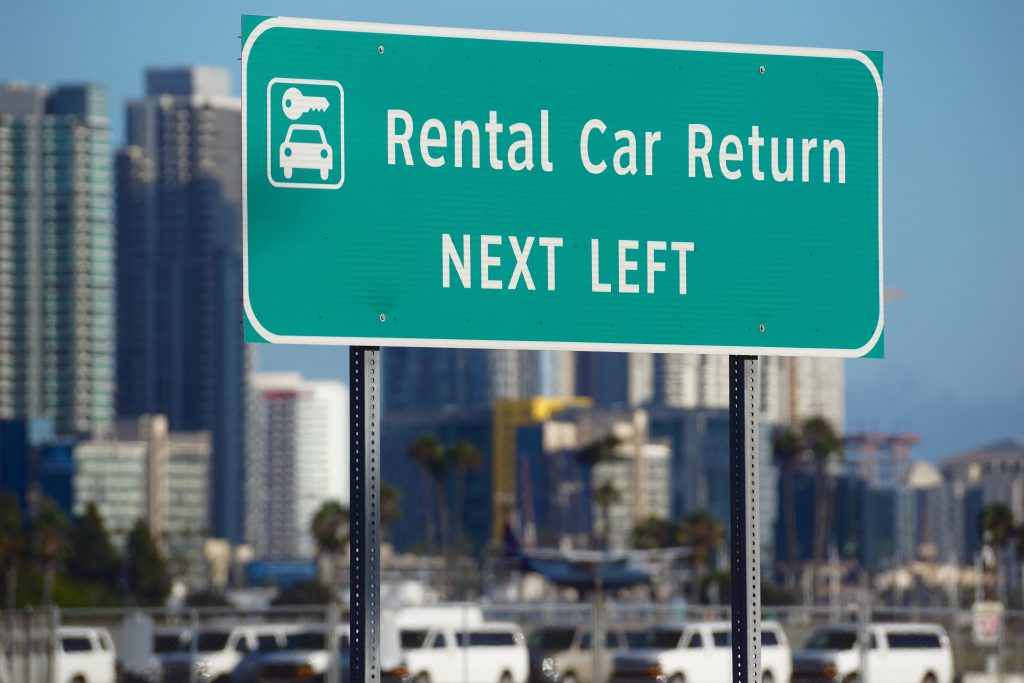 Grünes Schid mit Aufschrift: Rental Car Return NEXT LEFT