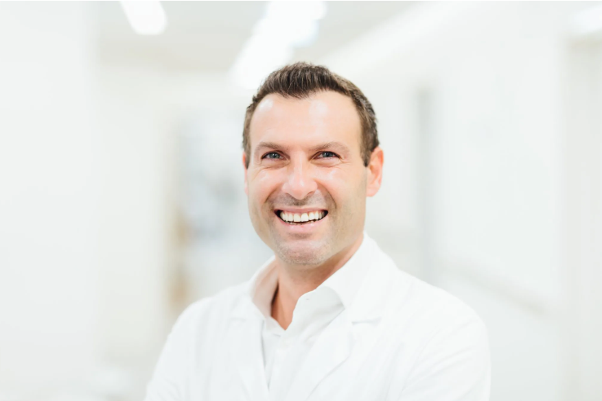 Schönheitschirurg René Draxler mit weißem Hemd lächelt in die Kamera