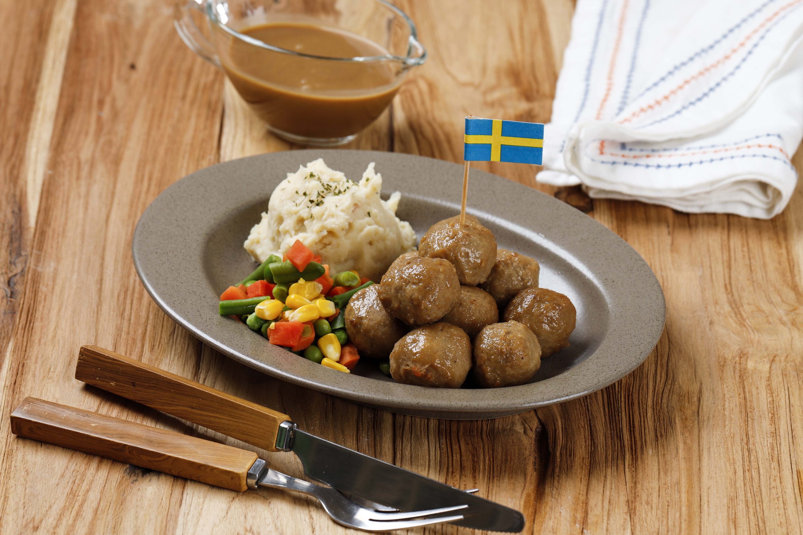 Fleischbällchen mit Gemüse und Reis mit der Fahne von Schweden