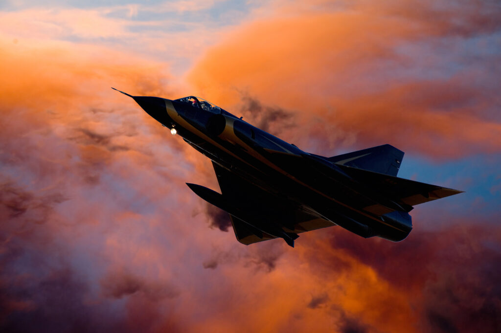 Kampfjet fliegt in den Sonnenuntergang
