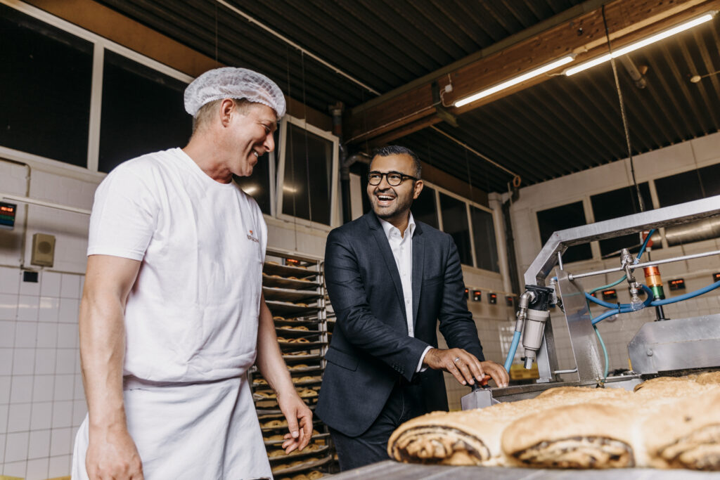 Eyüp Aramaz steht mit Bäckermitarbeiter in einer Bäckerstube 