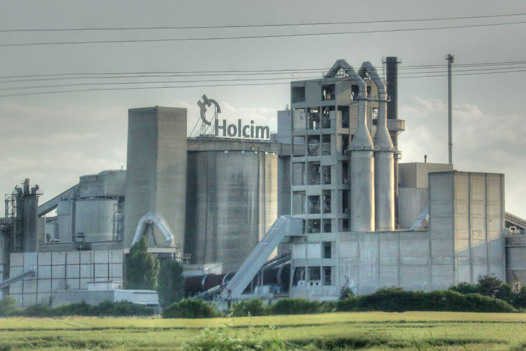 Fabrik von Holcim mit grüner Wiese davor
