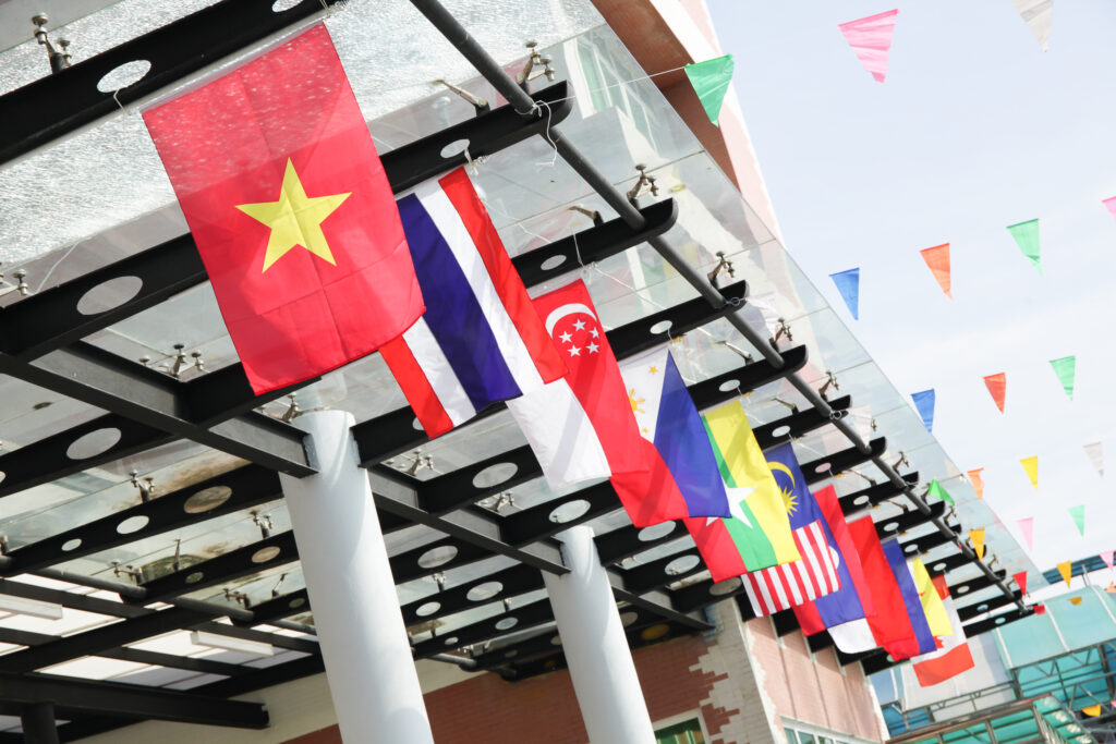 Flaggen von Republiken aus Asien hängen an einem Stahlträger bei einem Eingangsfoyer