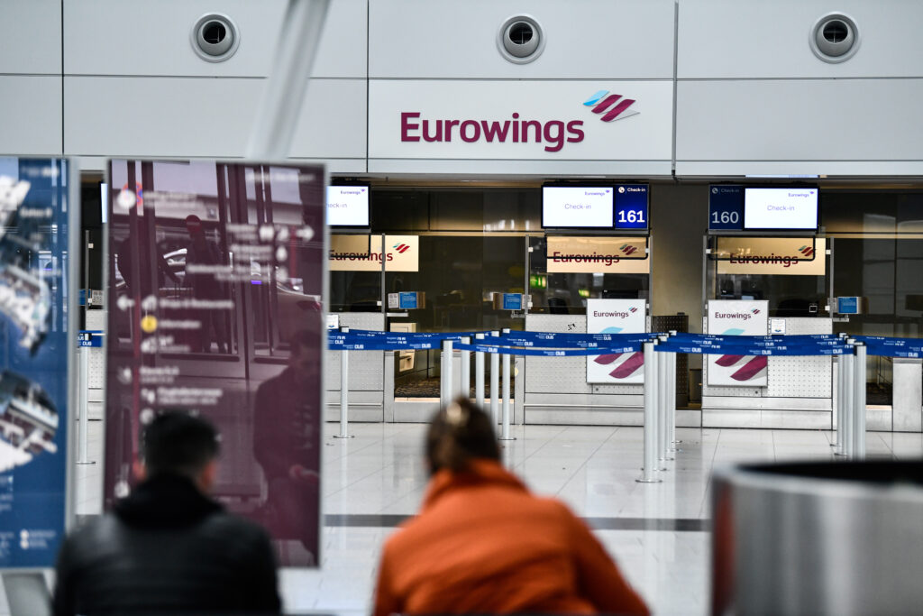 Personen warten vor dem Eurowings-Schalter am Flughafen