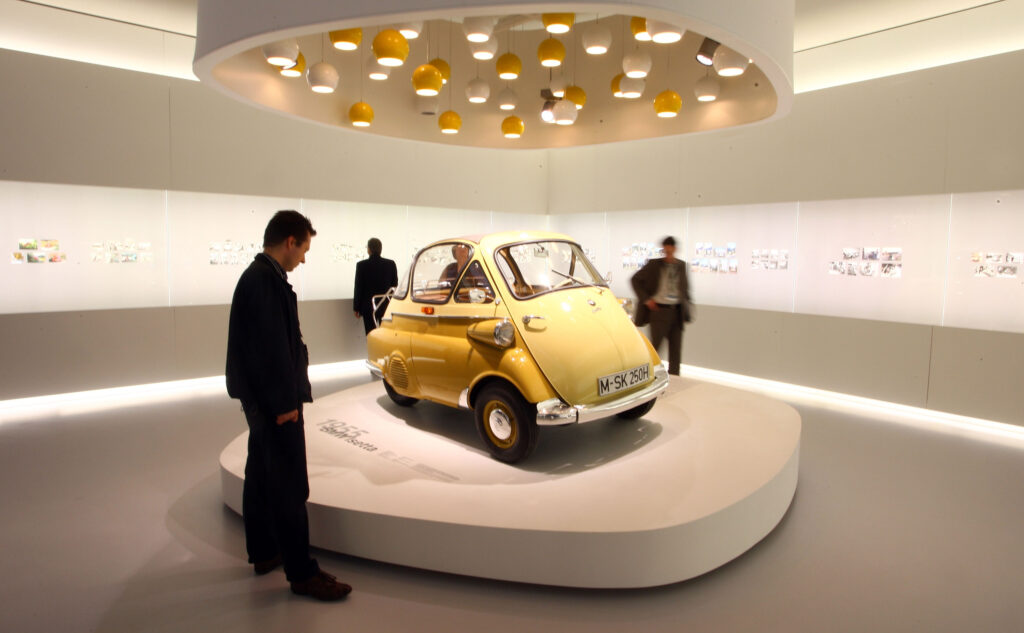 Besucher besichtigen die BMW Isetta im  BMW Museum