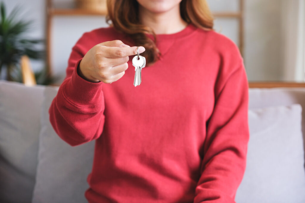 roter Pullover und eine Hand, die einen Schlüsselbund hält