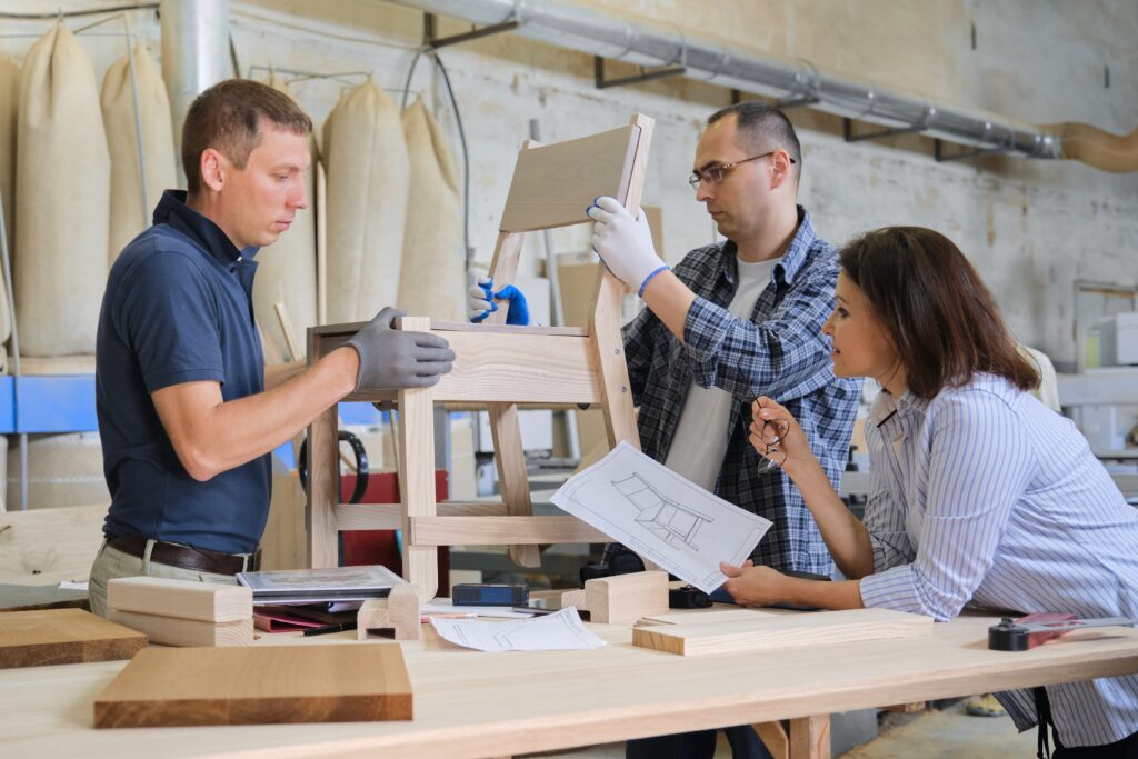 Zwei Männer und eine Frau arbeiten am Design eines Stuhls