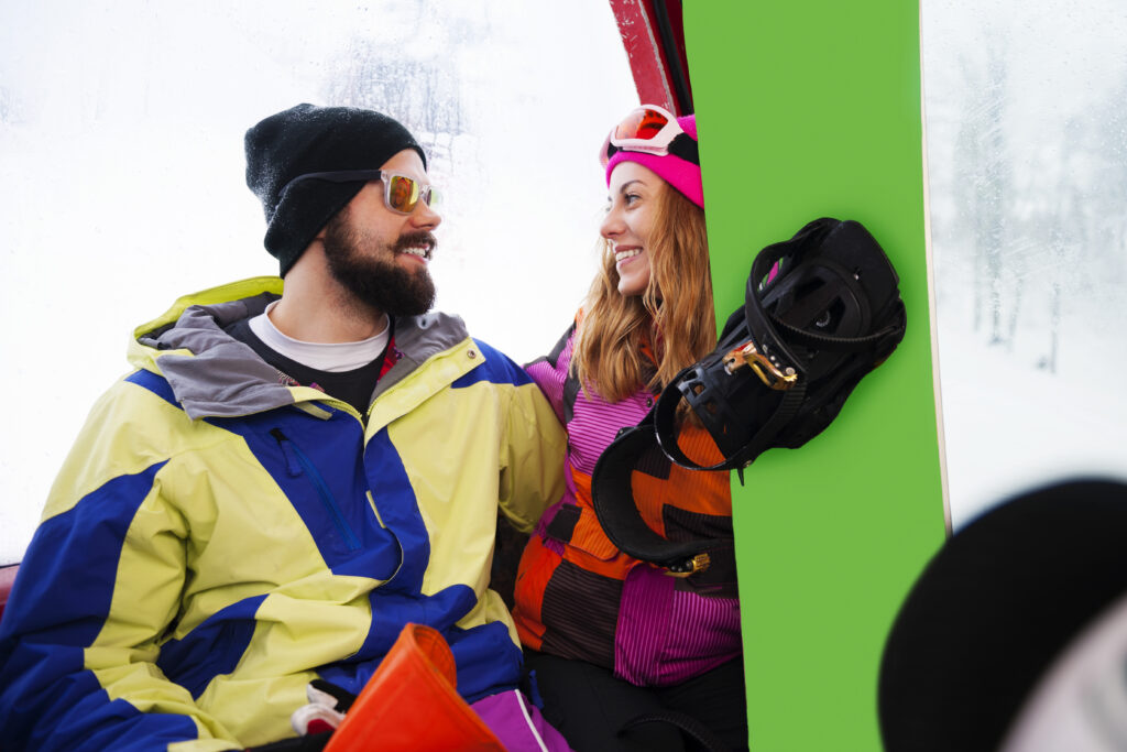 Mann und Frau im WInter. Frau hält Snowboard