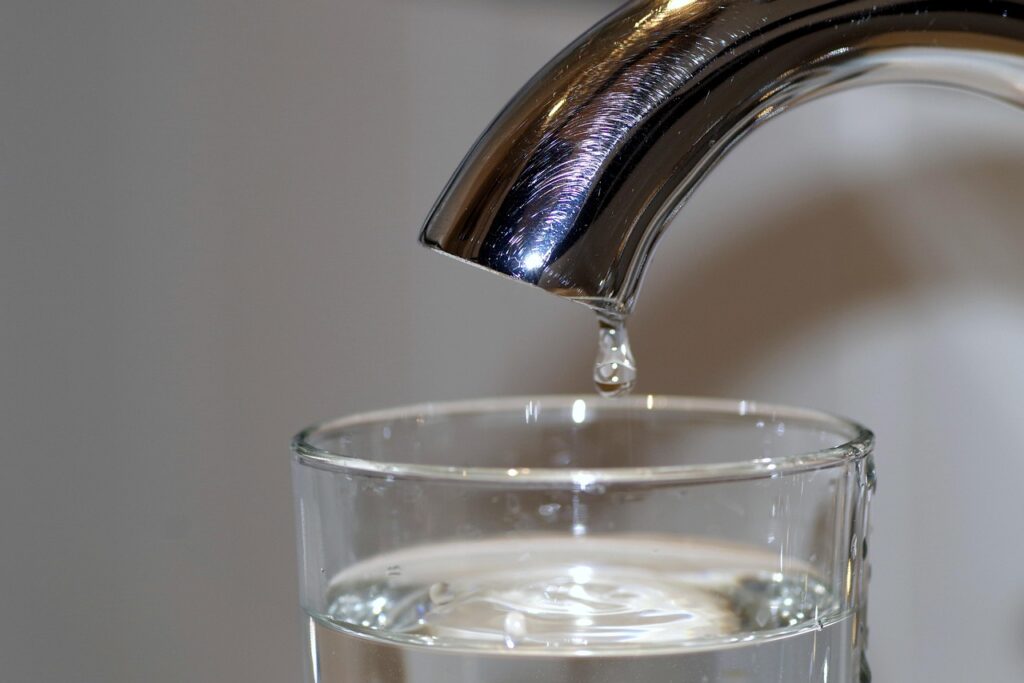 Ein Wasserglas wird unter einem Küchenhahn befüllt, nachdem das Abkochgebot in Feldkirchen für viele Haushalte aufgehoben wurde – Foto: Arcaion / Pixabay