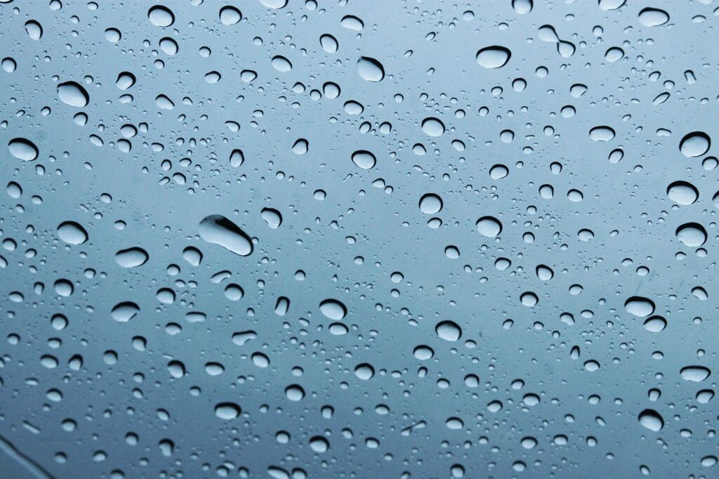Ein Gast bucht am Fenster bei Regenwetter eine Unterkunft mit Airbnb Wetterschutz auf dem Smartphone – Foto: TC-TORRES / Pixabay