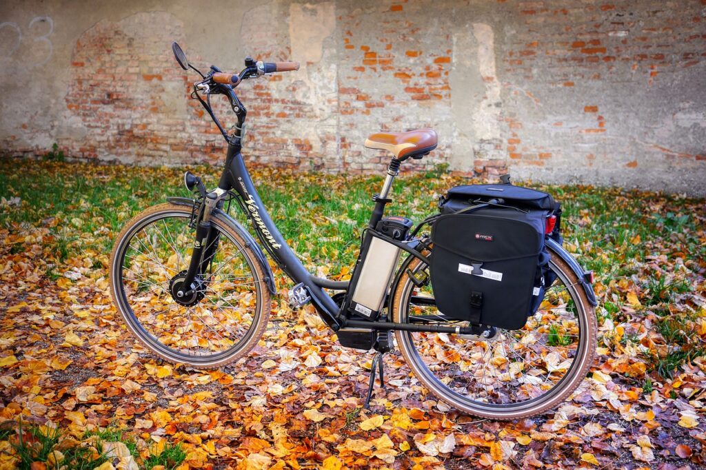 Ein E-Bike-Akku liegt neben einem Ladekabel auf einer Werkbank, Symbolbild für die Gefahr eines Akku-Brands – Foto: fietzfotos / Pixabay