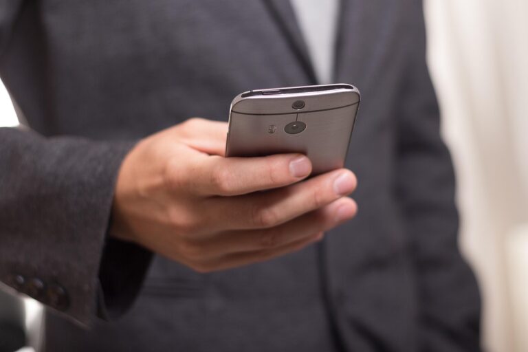 Eine Hand hält ein Smartphone mit Nachrichten, die auf Klimabonus Betrug per SMS hinweisen könnten – Foto: niekverlaan / Pixabay