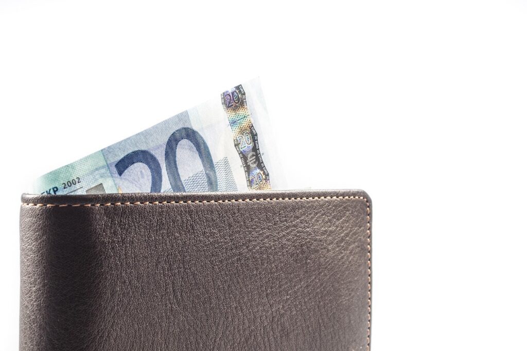 Ein Stapel Rechnungen und eine Geldbörse auf einem Tisch symbolisiert die steigende Zahl der Privatinsolvenzen in Deutschland – Foto: blickpixel / Pixabay