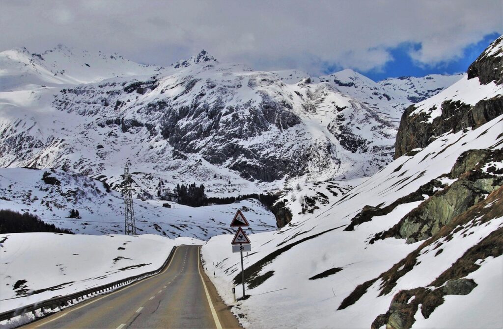 Verschneite Bergstraße in den Alpen zeigt den einsetzenden Schneefall in höheren Lagen – Foto: pasja1000 / Pixabay