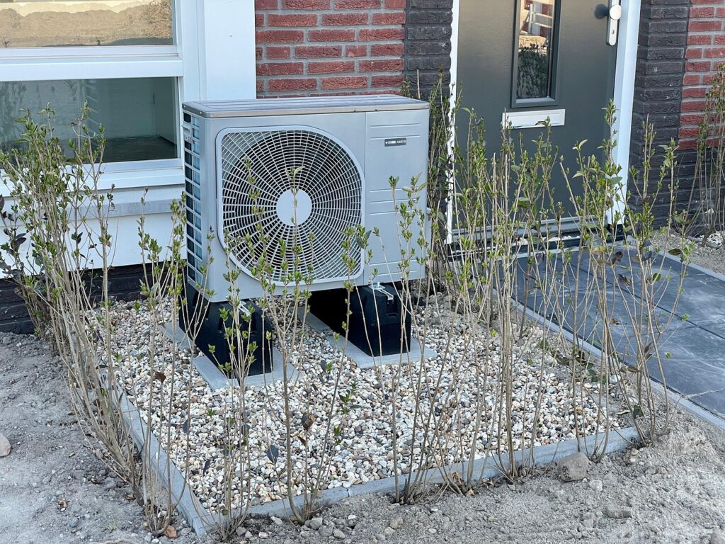 Eine Wärmepumpe steht vor einem Wohnhaus in Ahrensburg, wie sie beim Tag des offenen Heizungskellers zur Wärmemesse Ahrensburg gezeigt wird – Foto: HarmvdB / Pixabay